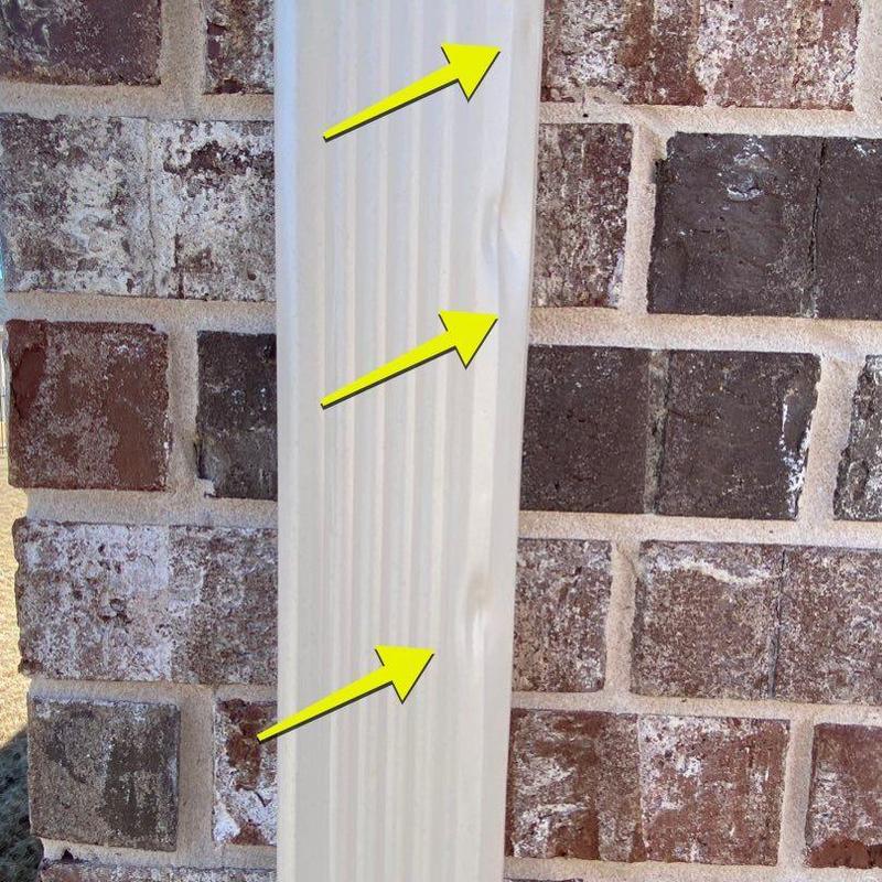 Gutter with hail damage dents marked by arrows