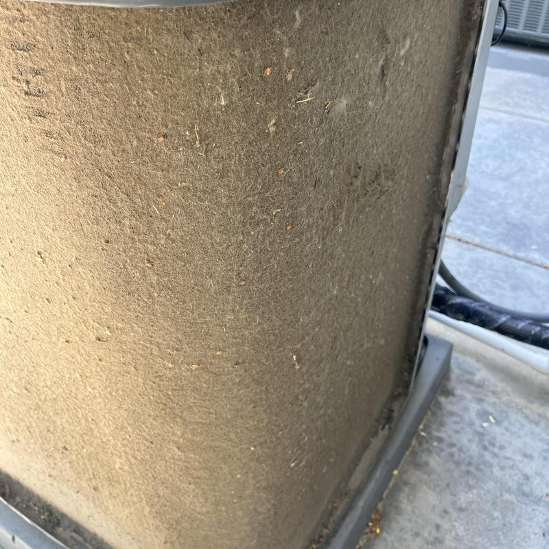Outdoor AC unit coil covered in dust and debris