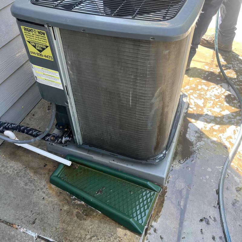 Outdoor AC unit condenser coil cleaning in progress