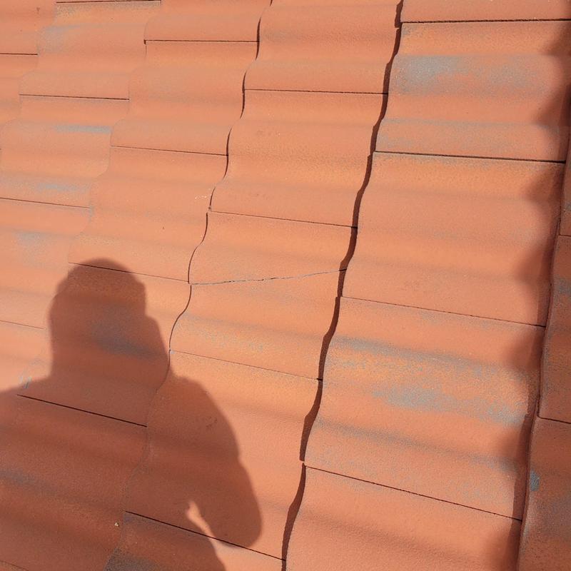 Concrete tile roof with cracked and slipped tiles
