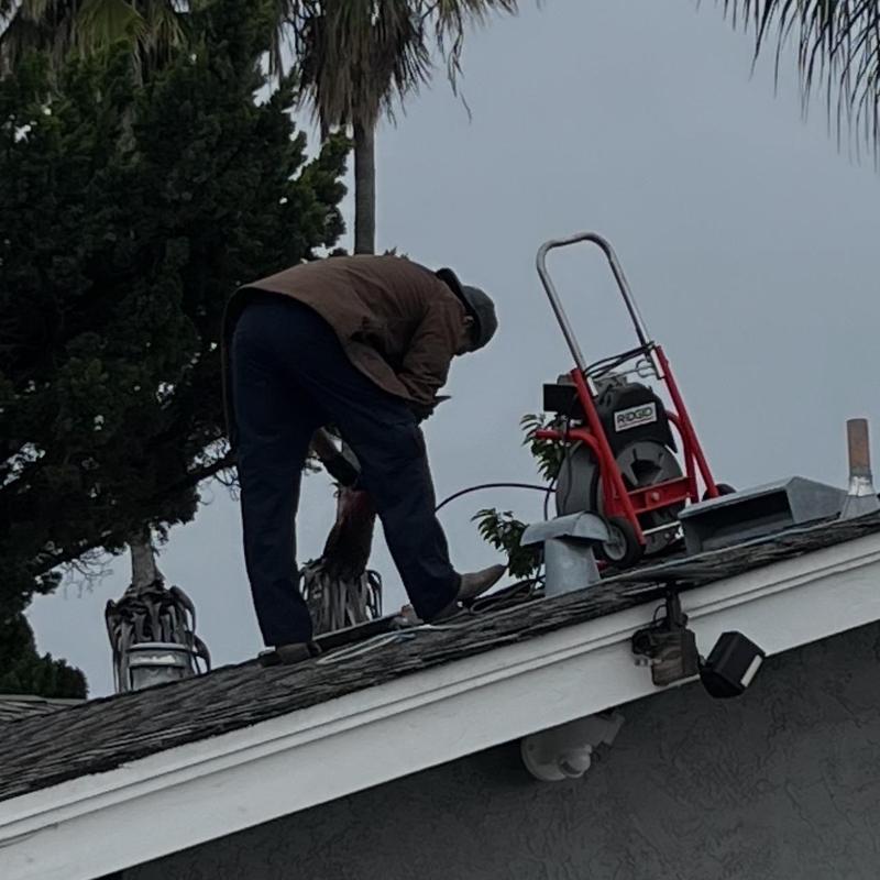 Washer drain snake cleaning on residential roof