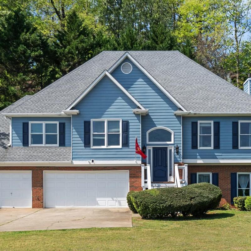 Asphalt shingle roof on blue house with garage