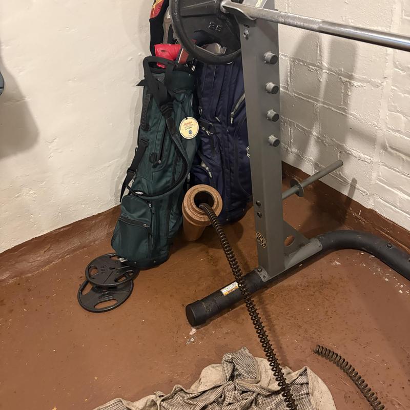 Main line drain with sewer snake in basement corner Main line drain with sewer snake in basement corner