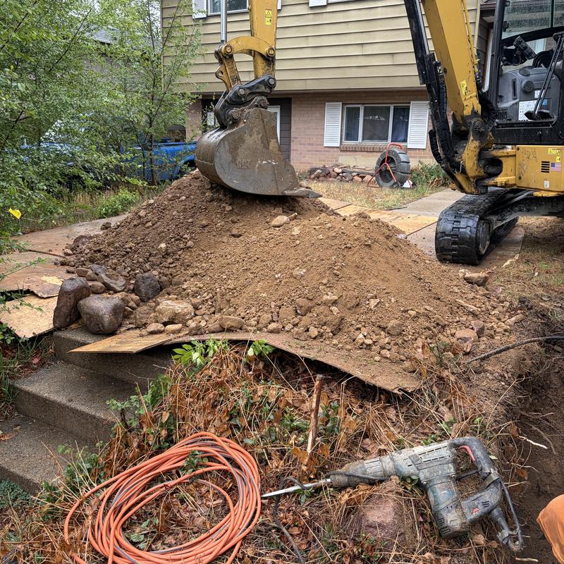 Sewer line excavation with backhoe and power drill