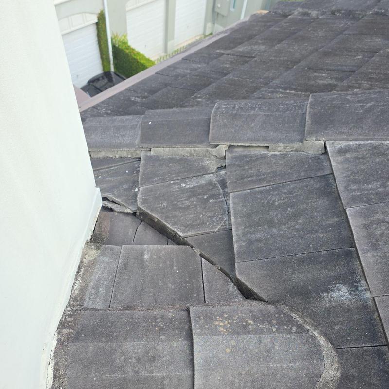 Concrete tile roof with broken tiles near wall