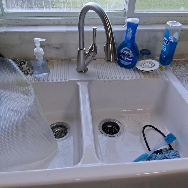 Kitchen faucet and double basin sink with cleaning supplies