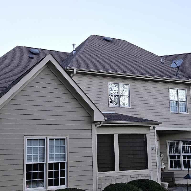 Asphalt shingle roof with beige siding on two-story house