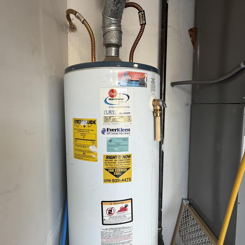Gas water heater installation in garage with copper pipes