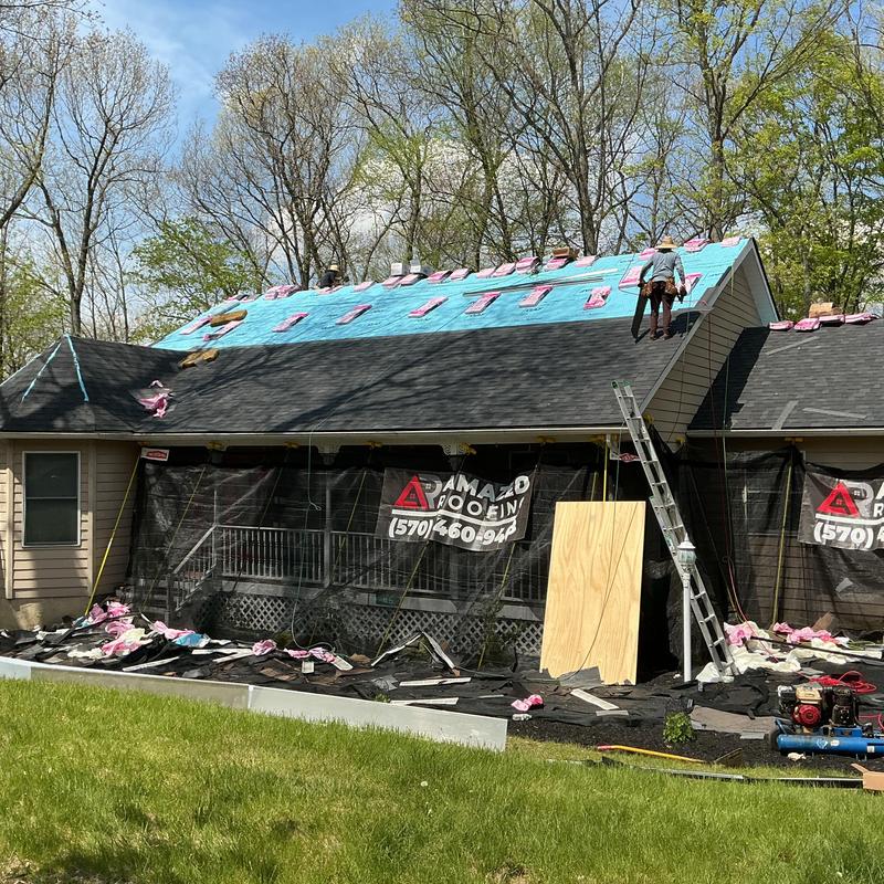 Roof shingles installation on house roof with workers Roof shingles installation on house roof with workers