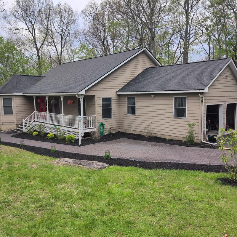 Asphalt shingle roof on beige house with porch and garage Asphalt shingle roof on beige house with porch and garage