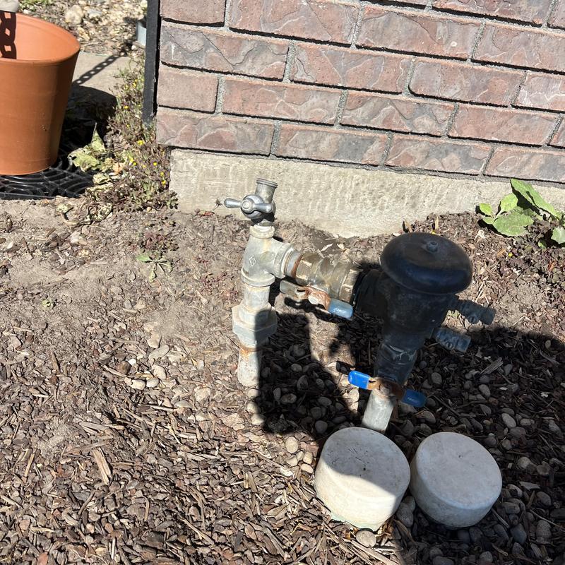 Watermain and backflow prevention assembly outside brick wall