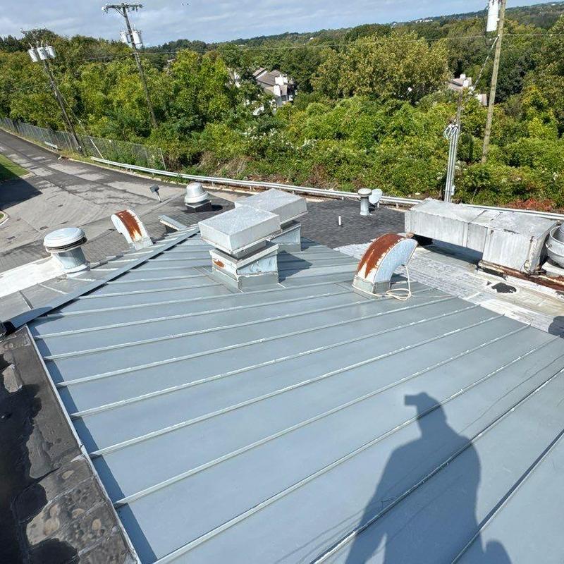 Metal standing seam roof with vent pipes and ductwork