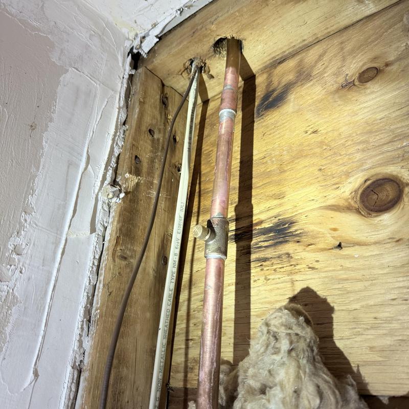 Copper water pipe with valve in wooden wall cavity Copper water pipe with valve in wooden wall cavity