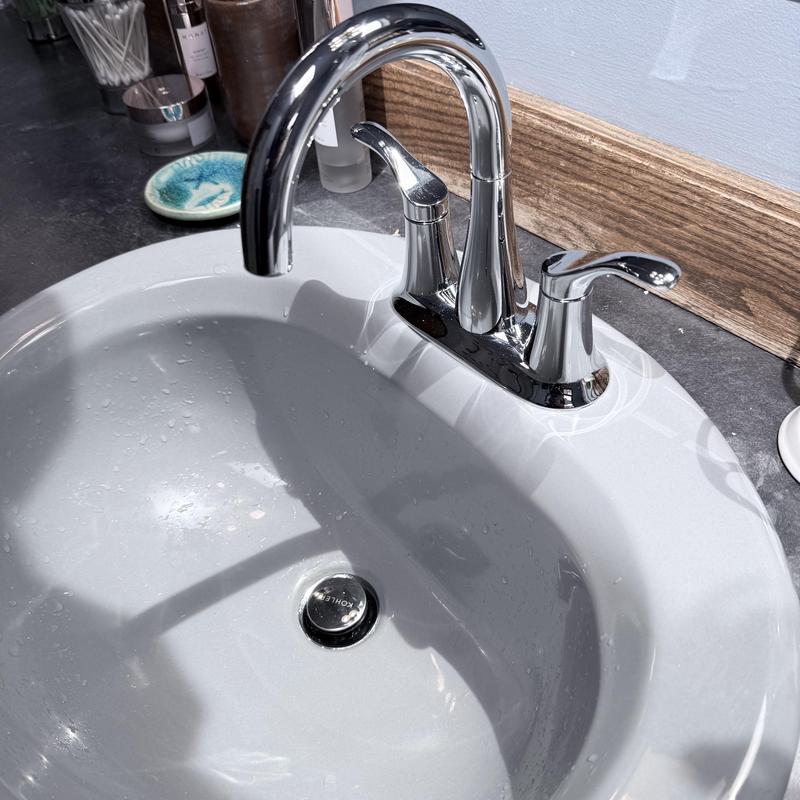 Bathroom faucet on white porcelain sink with droplets Bathroom faucet on white porcelain sink with droplets