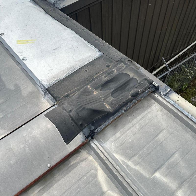 Commercial metal roof with hail damage patches