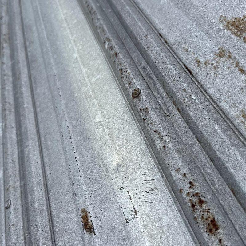 Metal roofing panels with hail damage and rust spots