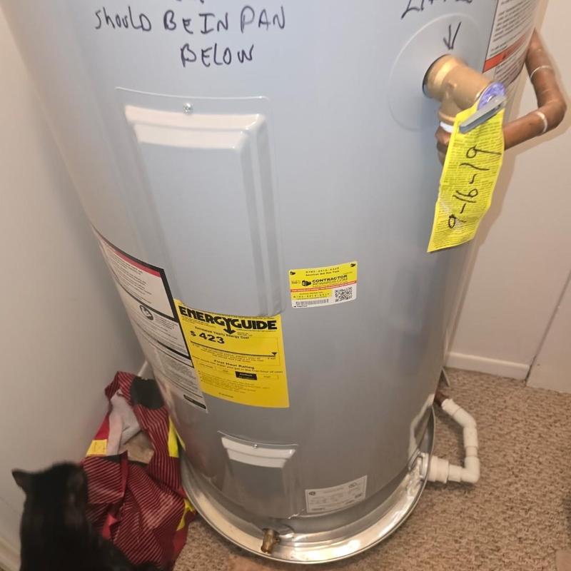 Water heater with handwritten notes and yellow tags