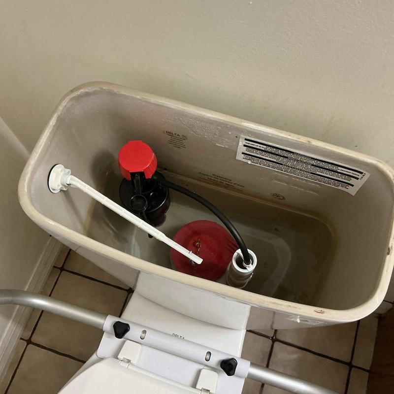 Toilet tank interior showing flush valve and fill components