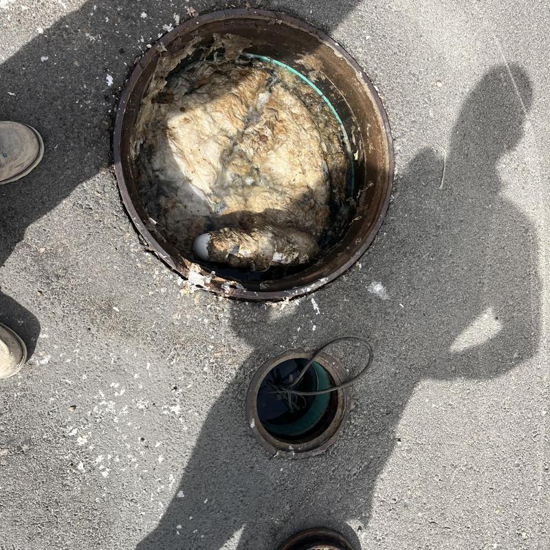 Clogged sewage pump basin with debris buildup