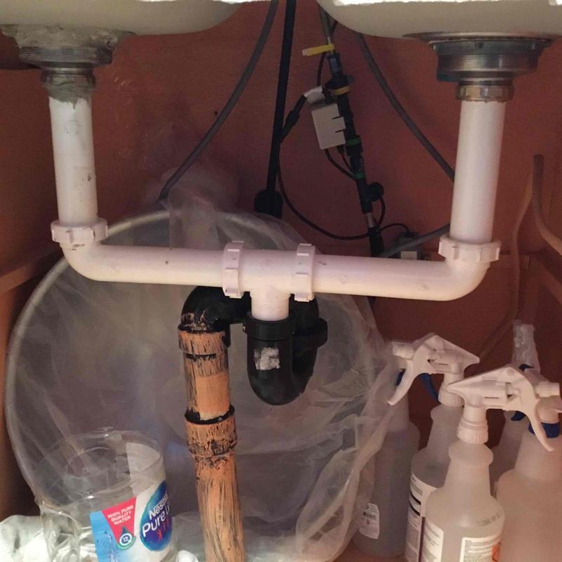 PVC kitchen sink drain and old cast iron pipe under cabinet
