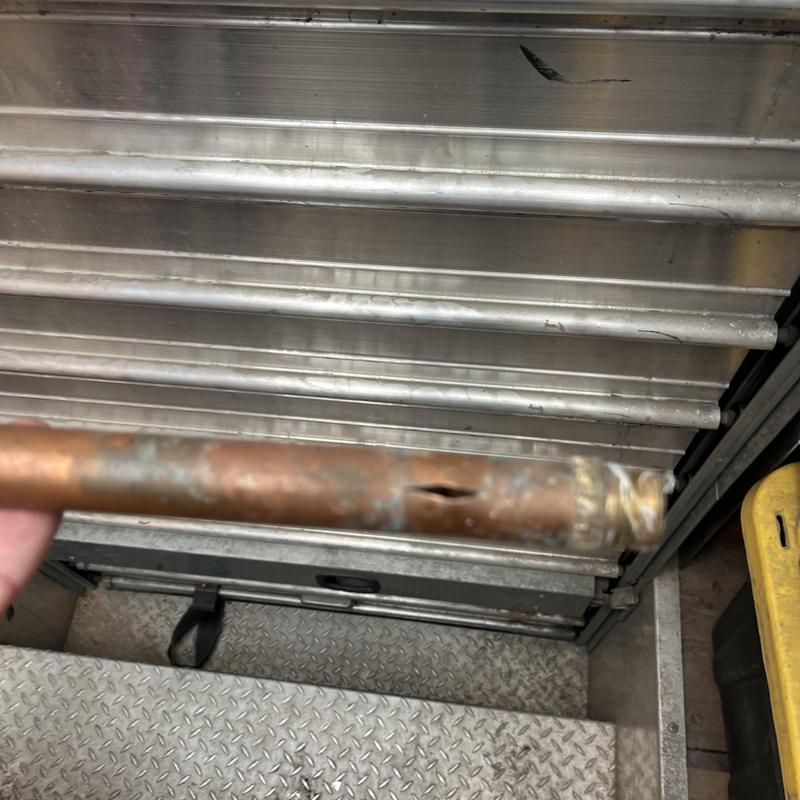 Copper pipe with visible split and corrosion damage