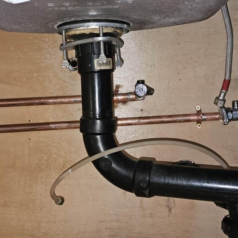 Copper water lines with sink drain piping under kitchen sink