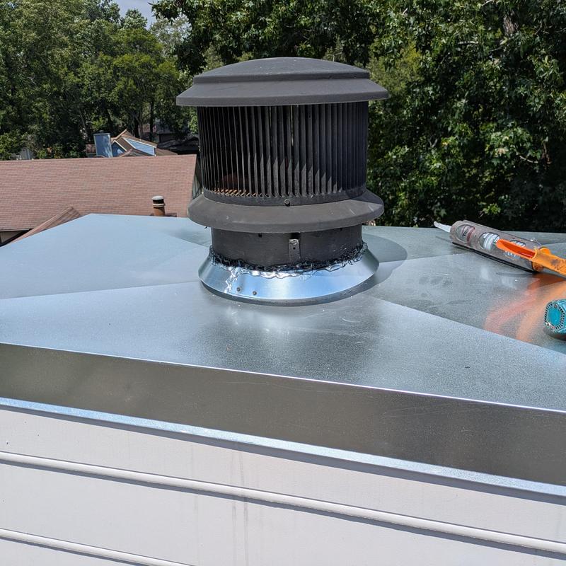 Chimney cap with new seal on metal roof peak