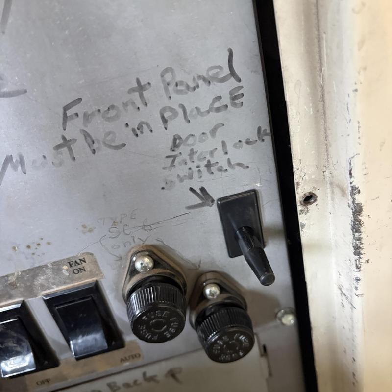Door interlock switch on metal control panel with knobs