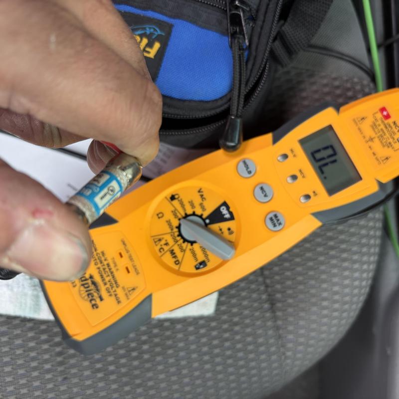 Fuse testing with clamp multimeter on technician's hand