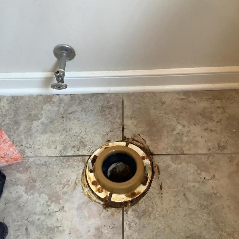 Toilet flange and water supply valve on tiled floor Toilet flange and water supply valve on tiled floor