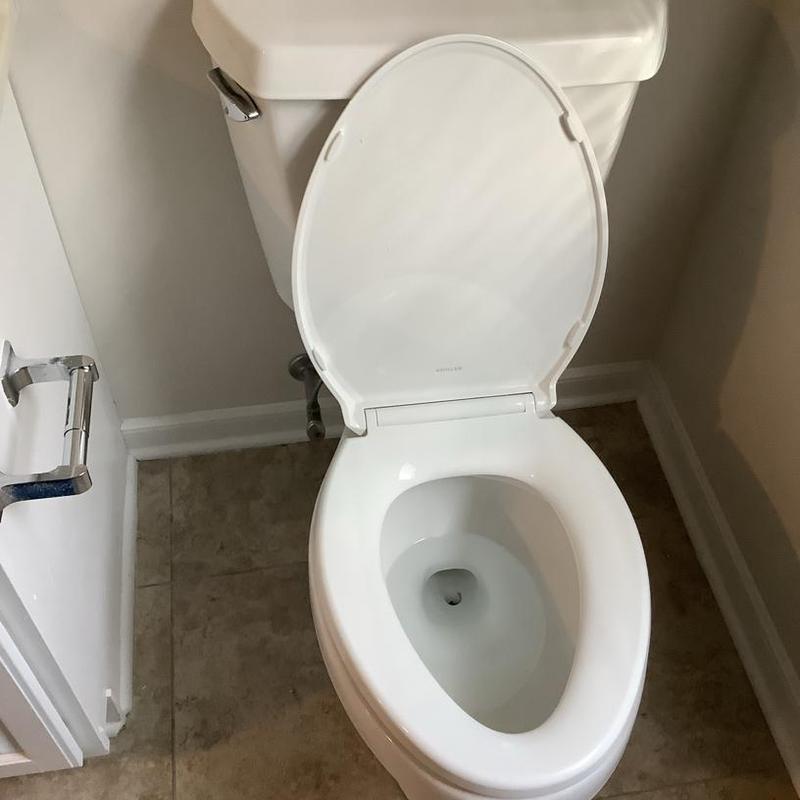 Toilet with open seat installed in residential bathroom Toilet with open seat installed in residential bathroom