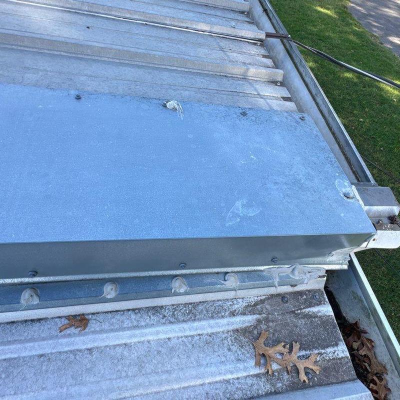 Metal ridge cap and flashing on corrugated metal roof
