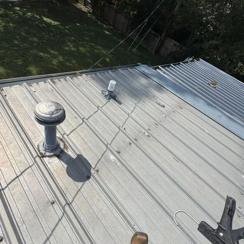Metal roof with ventilation pipes and hail damage