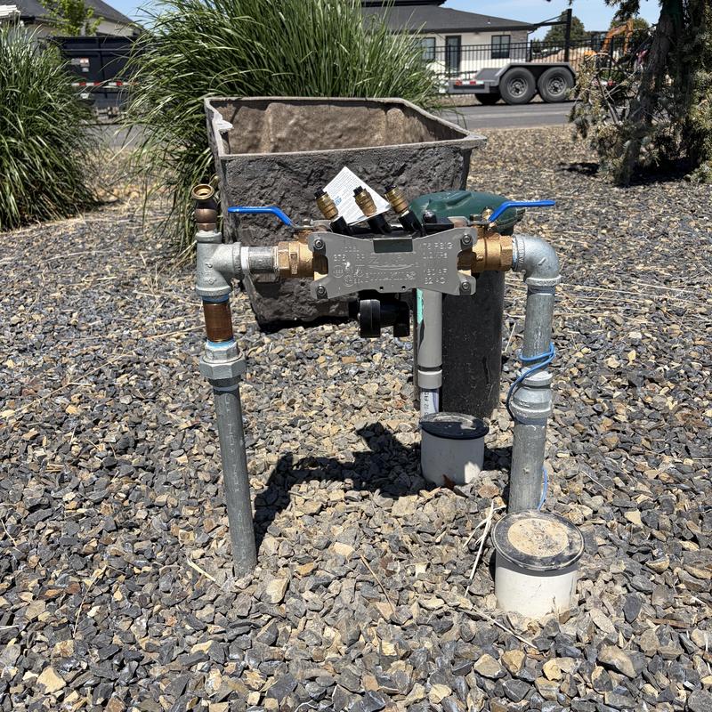 Backflow preventer assembly with valves and fittings outdoors