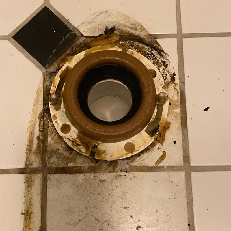 Toilet flange on tiled floor with sealant residue Toilet flange on tiled floor with sealant residue