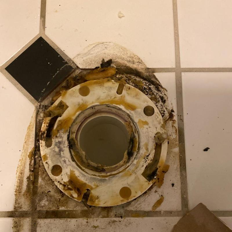 Toilet flange on tiled bathroom floor during replacement Toilet flange on tiled bathroom floor during replacement