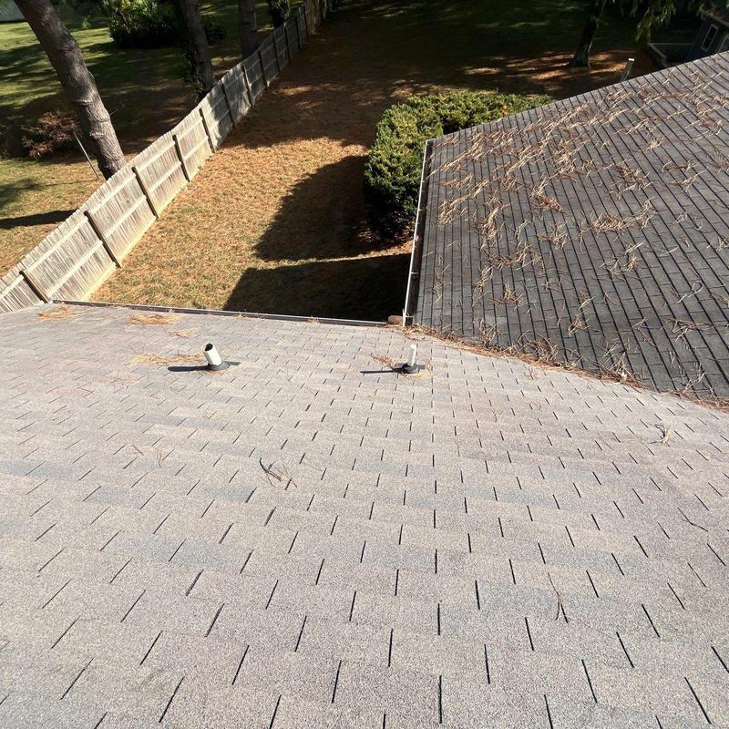 Shingle roof inspection showing roof vent pipes and debris