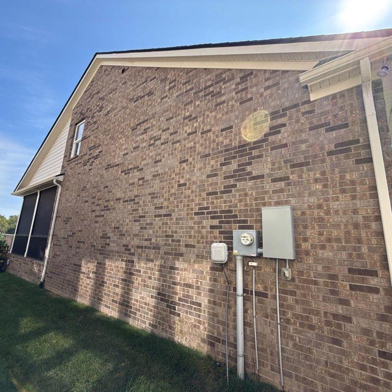 Brick exterior wall with electrical meter and panels