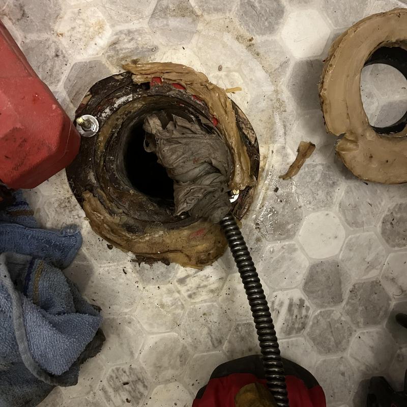 Toilet flange with sewer main clog and cable cleaning
