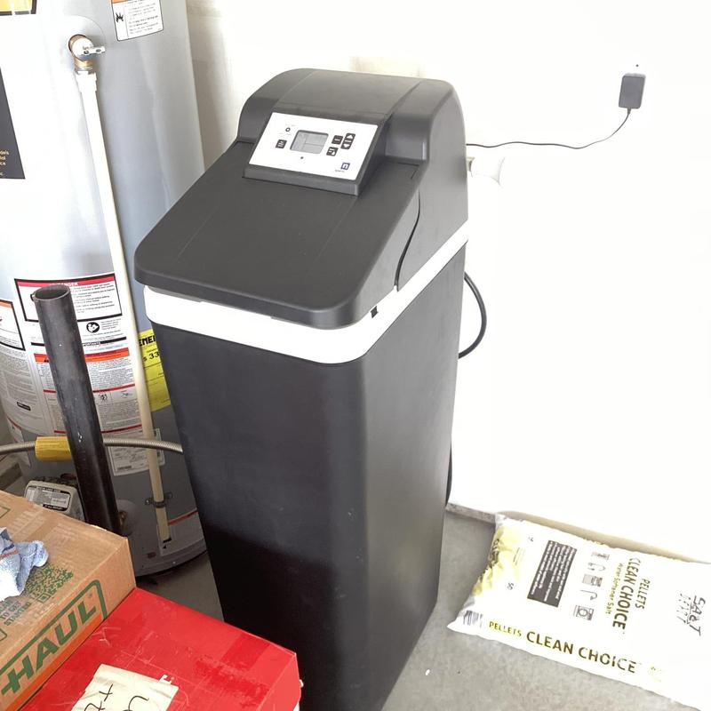 Water softener unit installed in garage with control panel