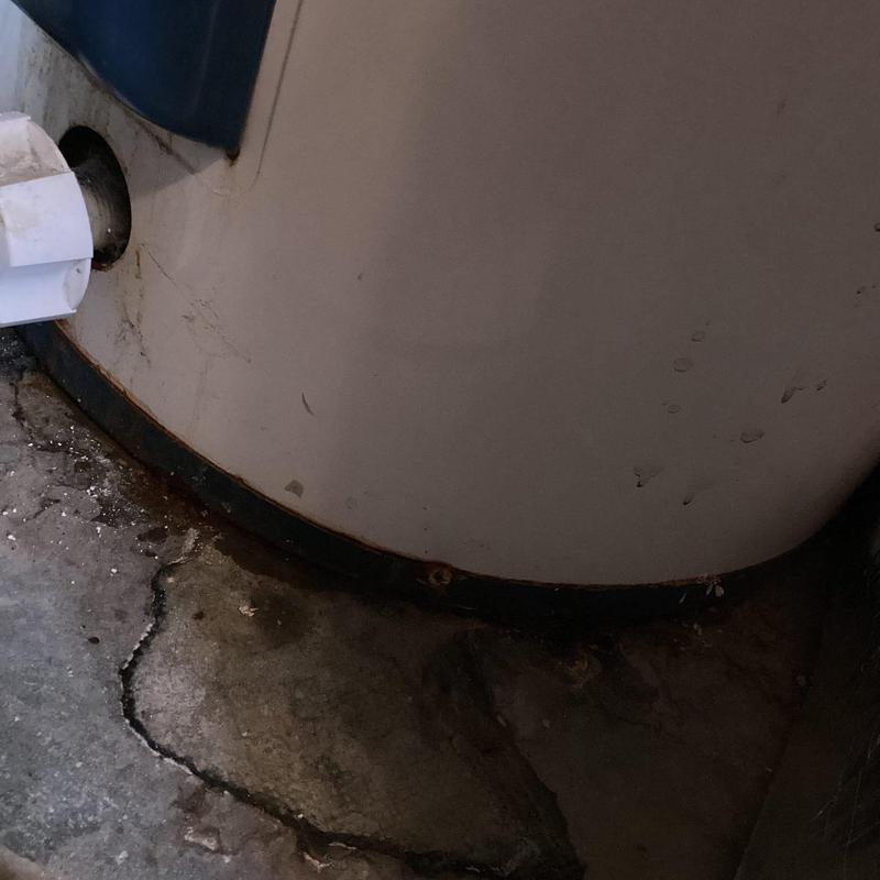 Water heater base and floor with rust and residue