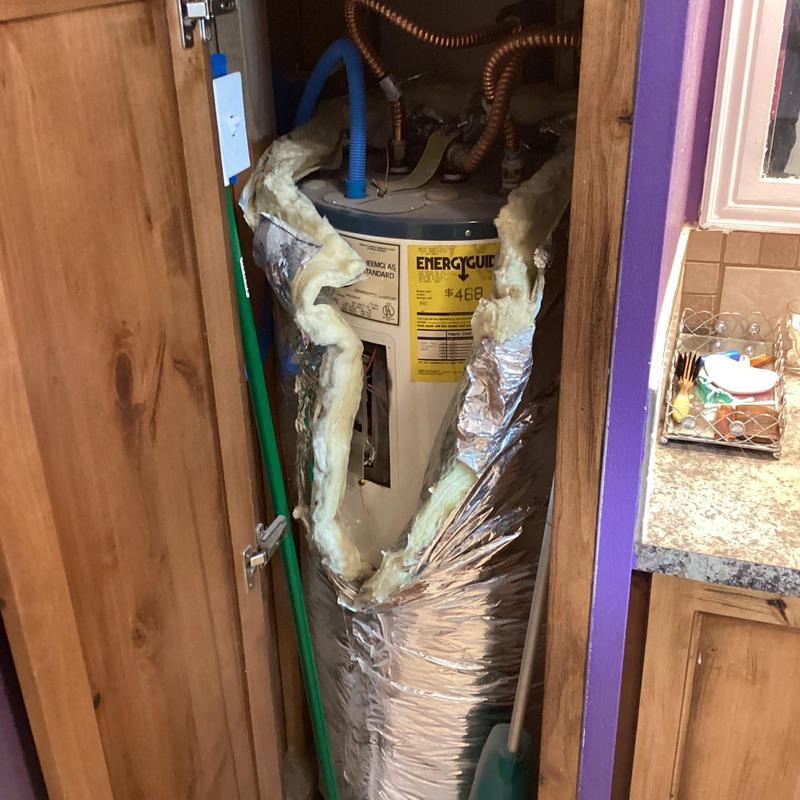 Electric water heater with torn insulation in closet
