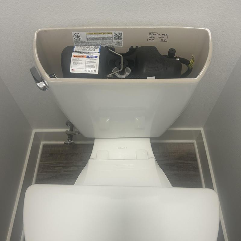 Pressure-assisted toilet tank interior in bathroom Pressure-assisted toilet tank interior in bathroom