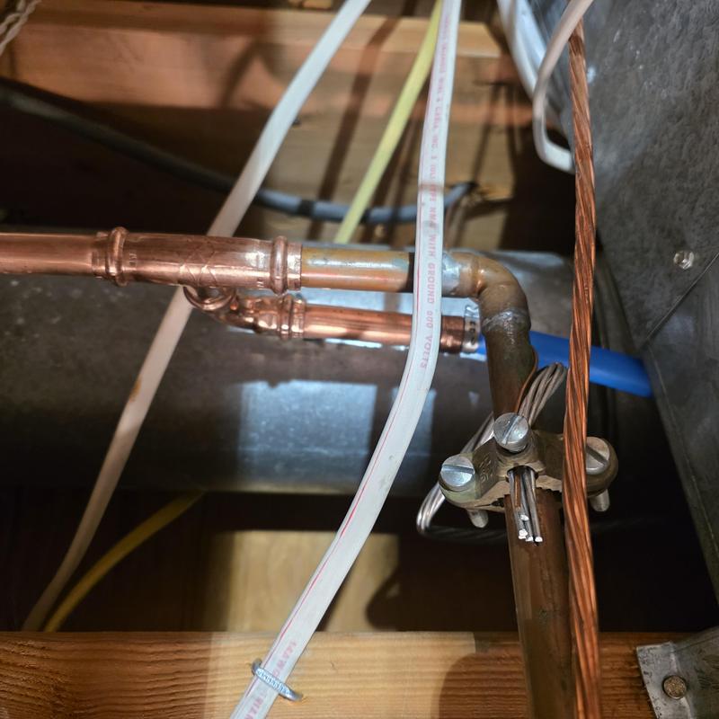 Copper water piping with grounding wire clamp installation