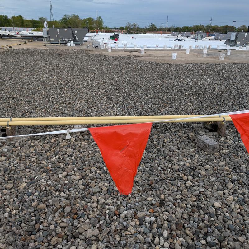 TPO single ply roof with ballast stones and safety flags