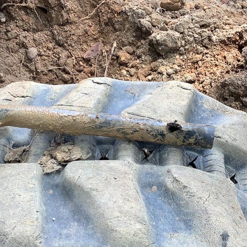 Main waterline pipe with puncture hole in soil Main waterline pipe with puncture hole in soil
