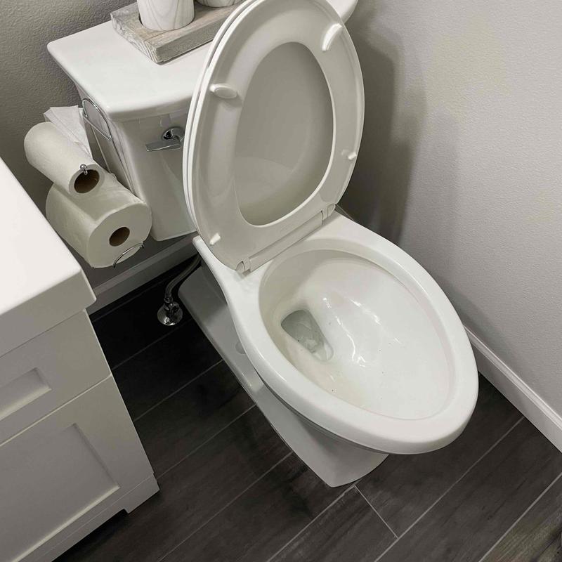 Toilet with open lid in bathroom corner