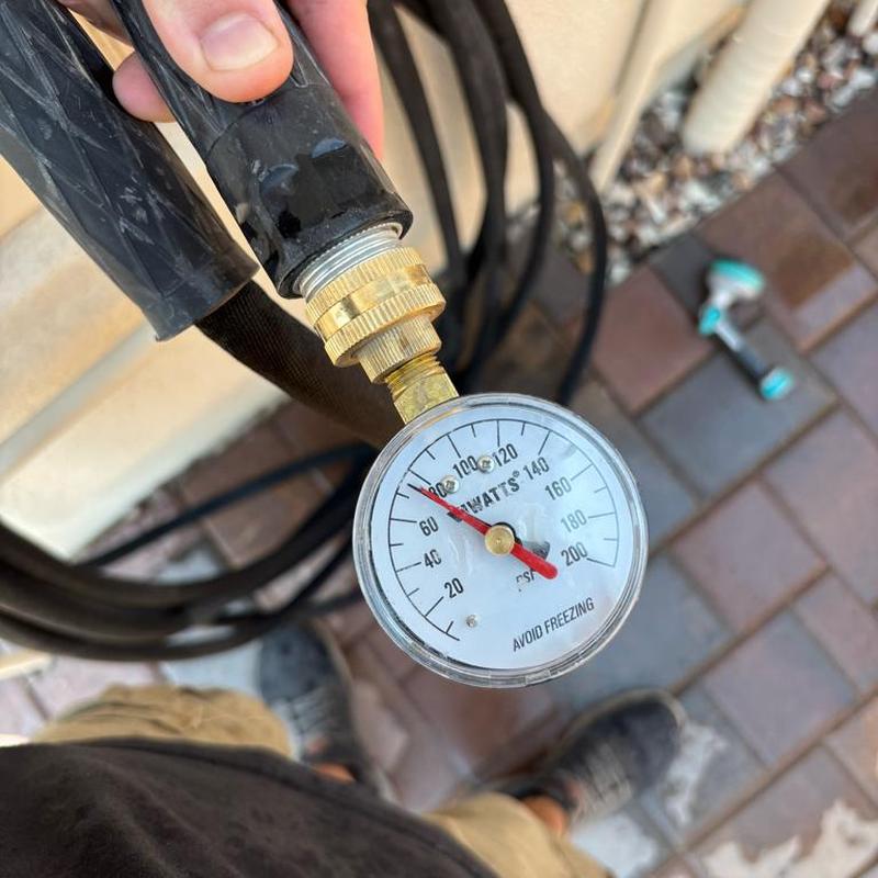 Water pressure gauge reading about 80 psi outdoors