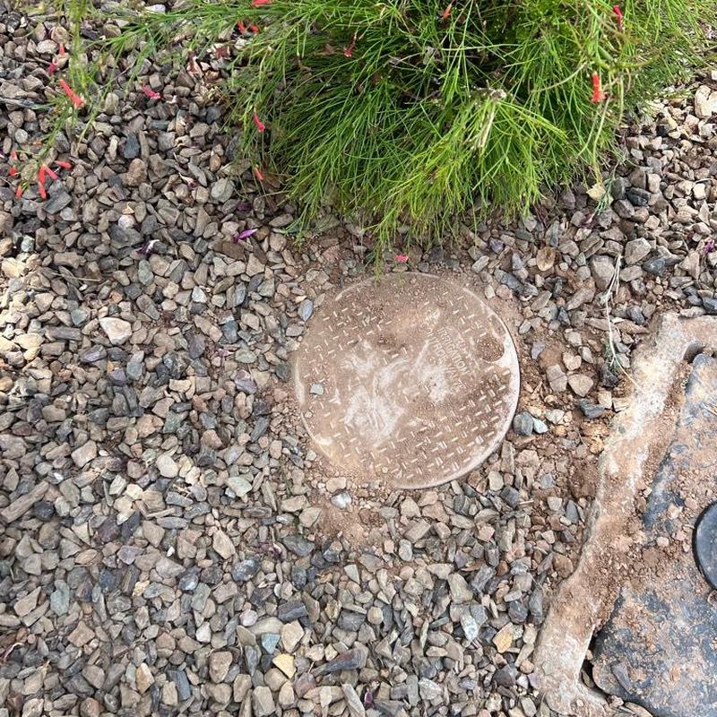 Pressure regulator valve access box with gravel landscaping