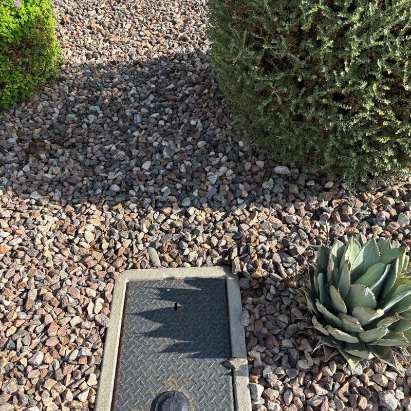 Pressure relief valve with tan access box in gravel bed